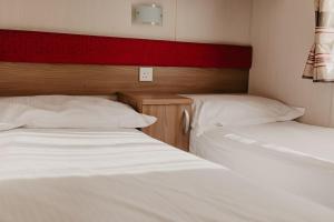 two beds in a room with white sheets at Lower Cliff 19 in Easton