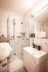 a white bathroom with a sink and a shower at Boutique-Apartment Südblick direkt im Zentrum in Oberstdorf