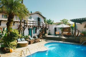 a swimming pool next to a building with a resort at Casa Aldeia Paraty in Paraty