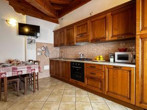 a kitchen with wooden cabinets and a table with a microwave at Appartamento Pommier in Saint-Pierre +7 photos