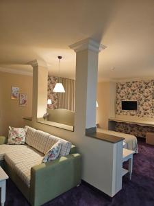 a living room with a couch and a tv at Parish Hotel in Svilengrad