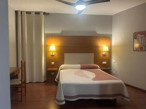 a bedroom with a bed and a ceiling fan at hotel rural ATALAYA in Alcañices