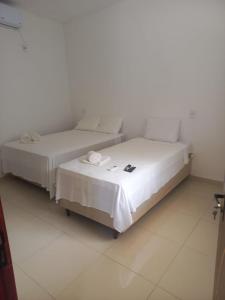 two beds sitting next to each other in a room at Apartamentos da Lua in Barreirinhas