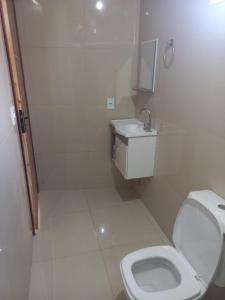 a white bathroom with a toilet and a sink at Apartamentos da Lua in Barreirinhas