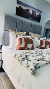 a white bed with a blanket on top of it at Dips And T Hotel & Spa in Bloemfontein