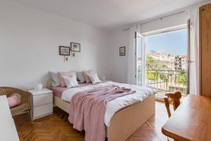 a bedroom with a bed and a large window at Holiday home with several apartments, a pool, sea views and a barbecue near Split in Podstrana