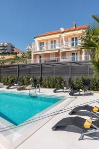 a swimming pool in front of a building at Holiday home with several apartments, a pool, sea views and a barbecue near Split in Podstrana