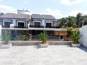 a house with two potted plants in front of it at HOMESTAY IMPIAN AYER MOLEK MUSLYM only in Malacca