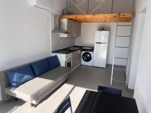 a small kitchen with a couch and a refrigerator at Casa Rural Las Vueltas in Mula