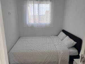 a bed in a white room with a window at Casa Rural Las Vueltas in Mula