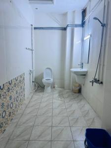 a bathroom with a toilet and a sink at Bab Al Bahrain Hotel in Manama