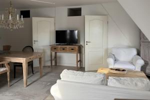 a living room with a couch and a table and a tv at BoLA 20 Fewo Hamburg mit Parkplatz & 2 SZ in Hamburg