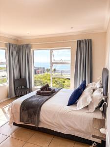 a bedroom with a large bed with a large window at On The Hill in Stompneusbaai