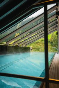 a view of a swimming pool through a window at Hotel Höllroah in Kappl