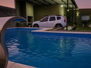 a white car parked next to a swimming pool at Los Horneros Zamba in Cerrillos