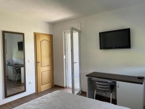 a bedroom with a bed and a television on the wall at Apartmani Mia in Prozor
