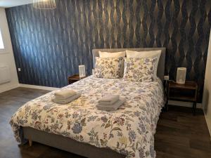 a bedroom with a bed with two towels on it at ANGEL Cozy duplex 2 chambres in Vitré