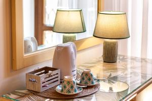 a table with a lamp and two cups on it at Duomo Apartments Affittacamere in Cefalù