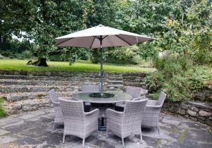 a table with chairs and an umbrella on a patio at College Hill House in Slane +16 photos