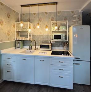 a kitchen with white cabinets and a white refrigerator at 2 SZ Ferienwohnung Hamburg zentral Parkplatz BoLA 24 in Hamburg +24 photos