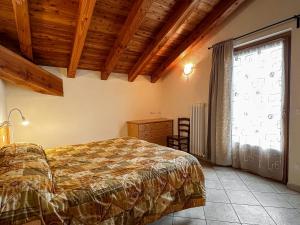 a bedroom with a bed and a large window at Appartamento Pommier 2 in Saint-Pierre