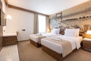 a hotel room with two beds and a tv at Hotel Royal Inn in Belgrade