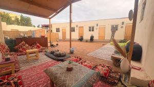 a living room with tables and a building in the background at SafeZone Guesthouse in Dahab