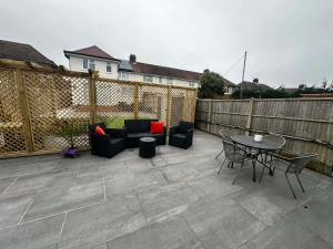 a patio with chairs and a table and a fence at Brain Properties Limited - Garden flat with Parking near QA Hospital in Portsmouth