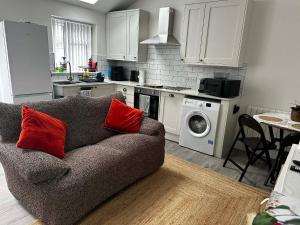 a living room with a couch and a kitchen at Brain Properties Limited - Garden flat with Parking near QA Hospital in Portsmouth