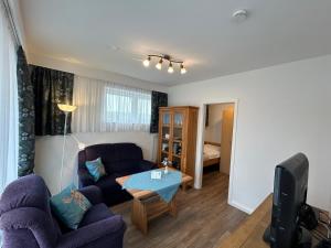 a living room with a couch and a table at Apartmenthaus am Watt Büsum in Büsum