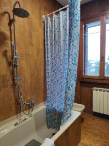 a bathroom with a shower with a blue shower curtain at 3 double bedrooms in Aloisia Home - near Venice Airport in Tessera