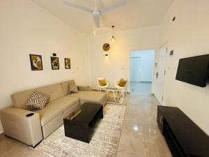 a living room with a couch and a flat screen tv at Malak house swimming pool &Garden in Luxor