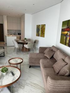 a living room with a couch and a table at Trilogy Limassol East Tower Seafront Apartment in Limassol