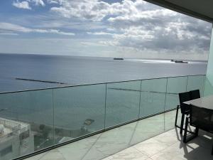 a view of the ocean from the balcony of a building at Trilogy Limassol East Tower Seafront Apartment in Limassol