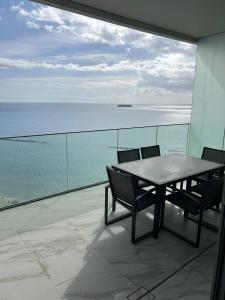 a table and chairs on a balcony with the ocean at Trilogy Limassol East Tower Seafront Apartment in Limassol