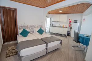 a bedroom with a large bed and a kitchen at Sunset Star II With Sea View in Calheta
