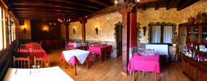 a restaurant with pink tables and chairs in a room at hotel rural ATALAYA in Alcañices +10 photos