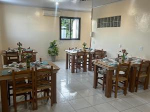 a dining room with wooden tables and chairs at Golden Hotel Ltda - Próximo a DPM, Aeroporto, Rodoviaria Porto Alegre, Arena do Grêmio in Porto Alegre +5 photos