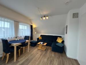 a living room with a couch and a table at Apartmenthaus am Watt Büsum in Büsum