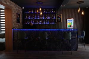 a bar with a blue counter and chairs at Hotel Joana in Prizren