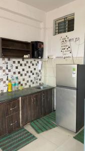 a kitchen with a stainless steel refrigerator and cabinets at Green male rooms in Bhopal