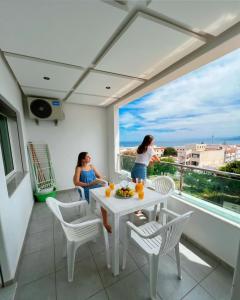 two women on a balcony with a table and chairs at Visit Chamal - Raihana in Oued Laou