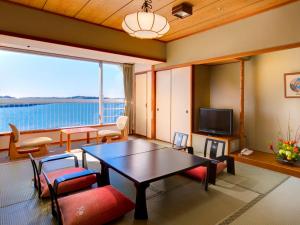 a living room with a table and chairs and a large window at Sago Royal Hotel in Hamamatsu