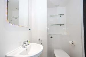 a white bathroom with a sink and a mirror at Studios For 2 Near Coventry Station in Coventry
