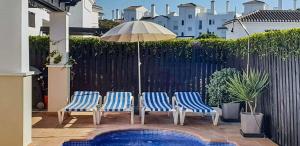 three chairs and an umbrella next to a pool at Villa with Private Pool - LO4LT in Torre-Pacheco