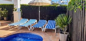 three chairs and an umbrella next to a swimming pool at Villa with Private Pool - LO4LT in Torre-Pacheco