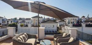 a patio with chairs and an umbrella on a balcony at Villa with Private Pool - LO4LT in Torre-Pacheco