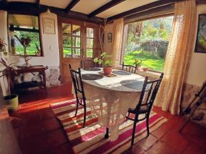 a dining room with a table and chairs and a window at The Witch's Cottage in Urubamba