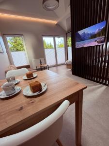a dining room with a wooden table and a tv at Apartament 59 Bystra Park in Bystra