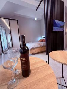 a bottle of wine sitting on a table with a wine glass at Apartament 59 Bystra Park in Bystra